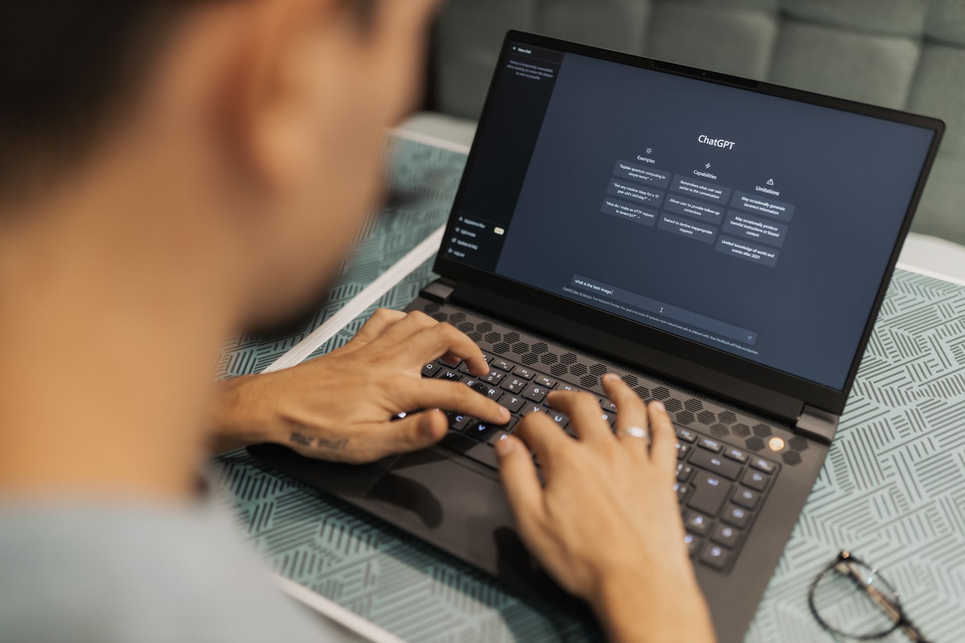 person typing on a laptop showing an AI chat interface with structured response